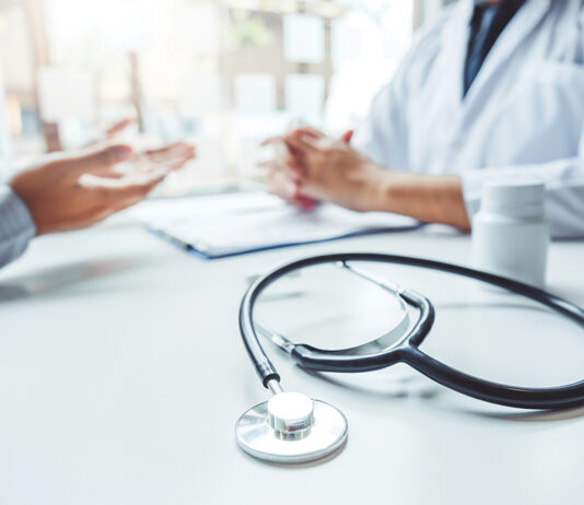 Doctors And Patients Consulting And Diagnostic Examining Sit And Talk. At The Table Near The Window In The Hospital Medicine Concept