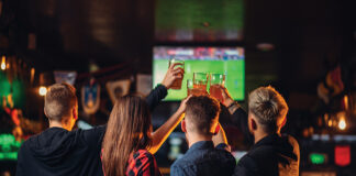 Friends Watches Football On Tv In A Sport Bar