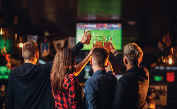 Friends Watches Football On Tv In A Sport Bar