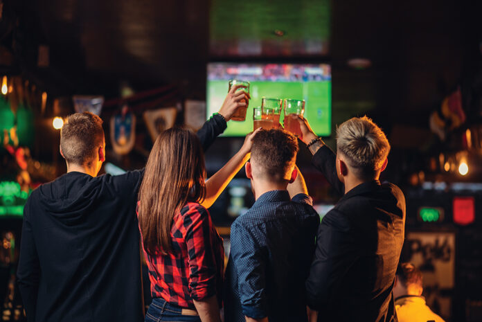 Friends Watches Football On Tv In A Sport Bar