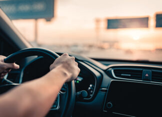 Hand Of Man Driving Car On The Road.