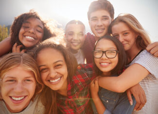 Teenage School Friends Smiling To Camera, Close Up