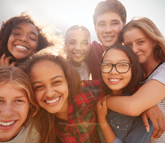 Teenage School Friends Smiling To Camera, Close Up