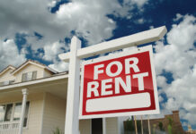Red And White For Rent Sign In Front Of House