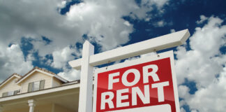 Red And White For Rent Sign In Front Of House
