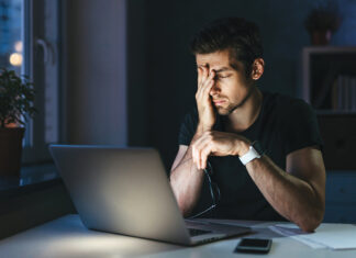 Young Overworked Man With Laptop At Night