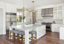 Beautiful Kitchen In New Luxury Home With Island, Pendant Lights, And Hardwood Floors