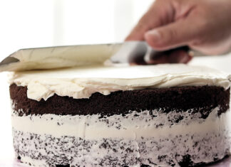 Spreading White Butter Cream On Homemade Chocolate Cake.