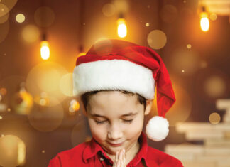 Praying child in Christmas hat