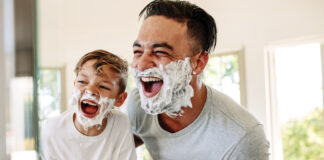 Father And Son Having Fun While Shaving In Bathroom