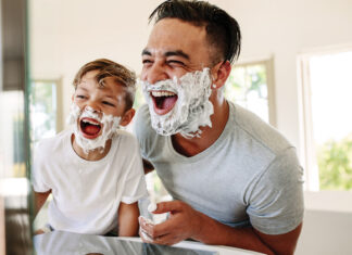 Father And Son Having Fun While Shaving In Bathroom