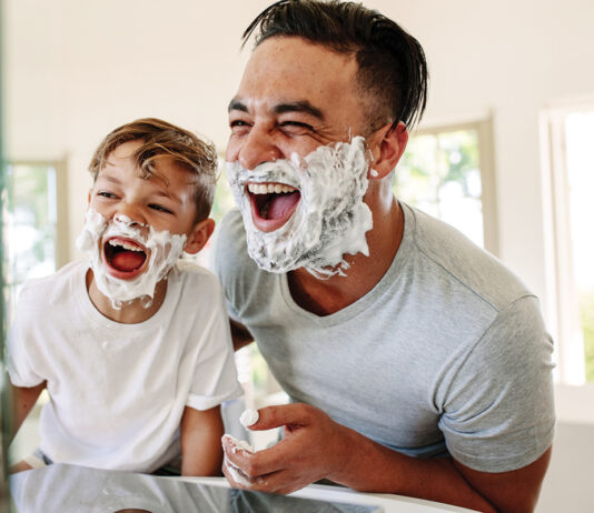 Father And Son Having Fun While Shaving In Bathroom