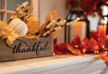 Fall Holiday Mantel Decorated With Colorful Leaves And Twinkle Lights