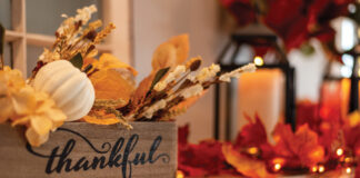 Fall Holiday Mantel Decorated With Colorful Leaves And Twinkle Lights