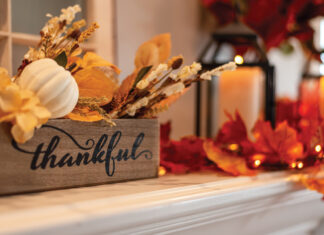 Fall Holiday Mantel Decorated With Colorful Leaves And Twinkle Lights