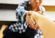 Close Up Handshake For Help Homeless Man On Walking Street In The Capital City.