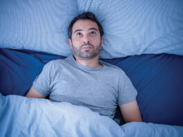Anxious Man Trying To Sleep But Suffering Insomnia